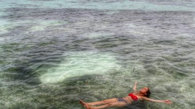 Amanda flutua em água cristalina de praia em Seychelles.