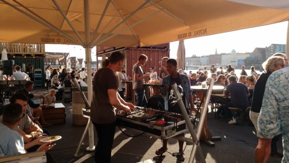 Em uma tenda, DJ anima a tarde para as pessoas em Papirøen, Copenhagen, Dinamarca.