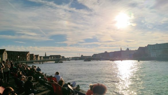 Pessoas curtindo o entardecer de frente para o rio em Papirøen, Copenhagen, Dinamarca.