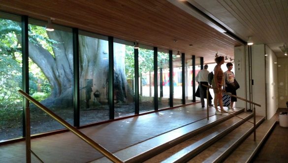 Interior do Louisiana Museum of Modern Art, com paredes de vidro que deixam visível o jardim, em Copenhagen, Dinamarca.