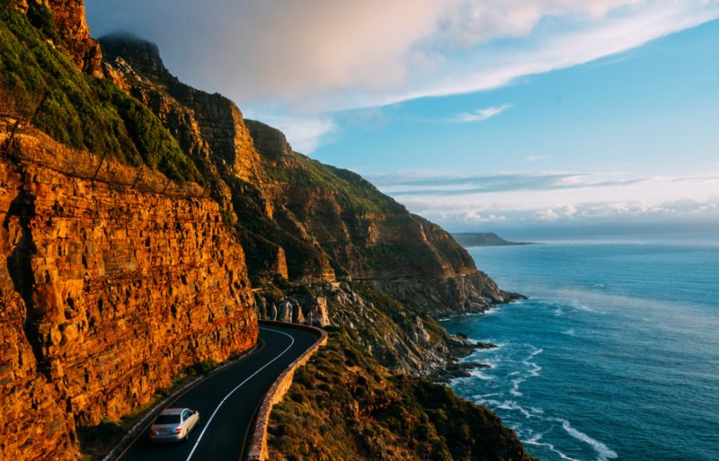 Estrada circundando montanha banhada pelo mar em Chapman's Bay e Peak, perto de Cape Town, África do Sul.