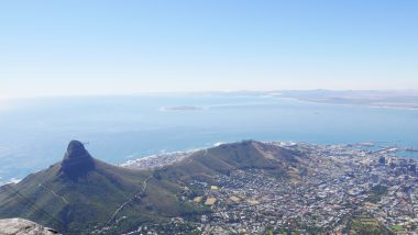Vista do topo da Table Moutain mostrando parte da cidade Cape Town protegida por um lado da montanha e banhado pelo mar do outro lado.