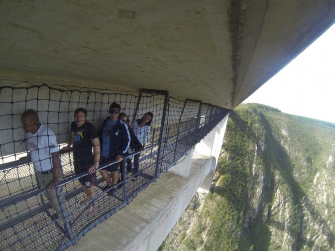 Foto de pessoas em corredor cercado por redes ao longo da ponte onde acontece o maior bungee jump de ponte do mundo, na África do Sul.