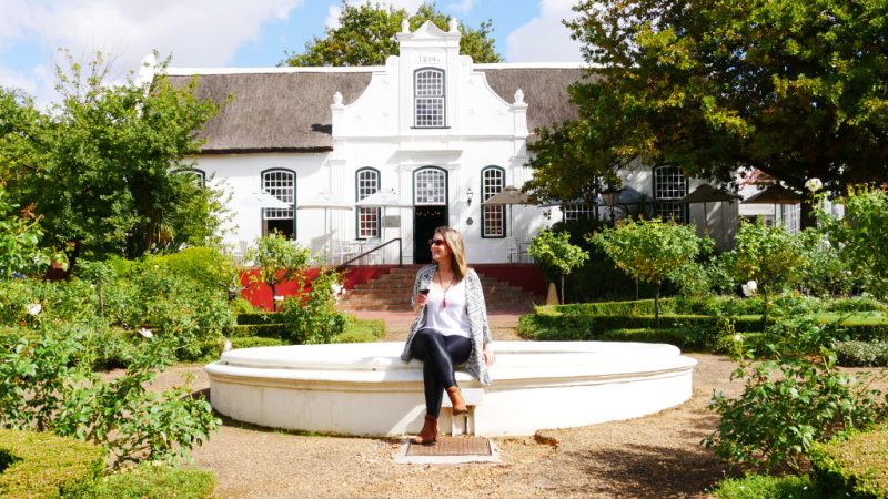 Com taça de vinho na mão, Amanda admira a paisagem em vinícola da região Franchhoek, na África do Sul.