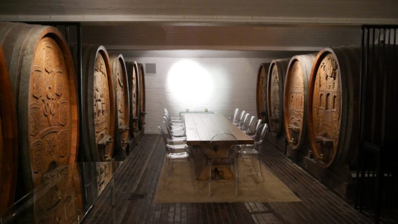 Sala de degustação cercada por imensos barris de vinho em vinícola da região Stellenbosch na África do Sul.
