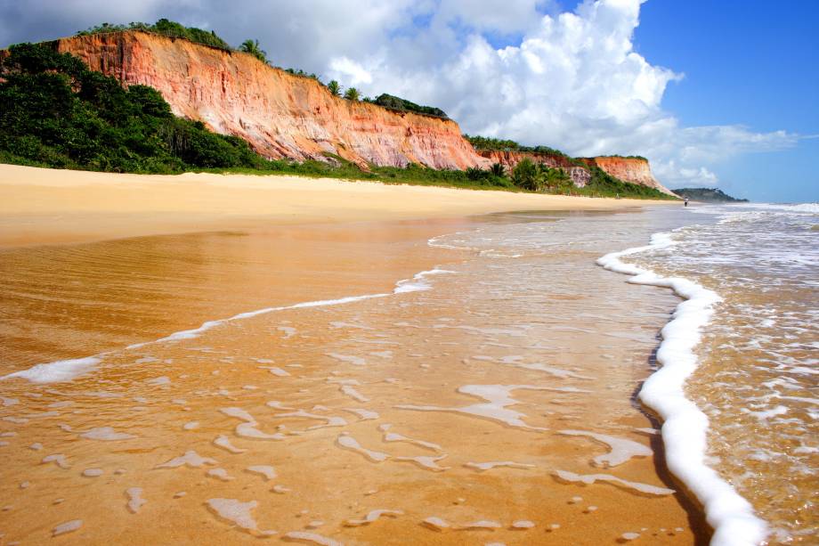 Onda molhando a areia na encosta da Praia do Taípe