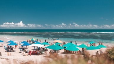 Orla da praia com banhistas aproveitando dia do sol em Porto de Galinhas, Permanbuco.