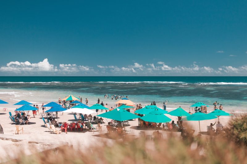 Orla da praia com banhistas aproveitando dia do sol em Porto de Galinhas, Permanbuco.